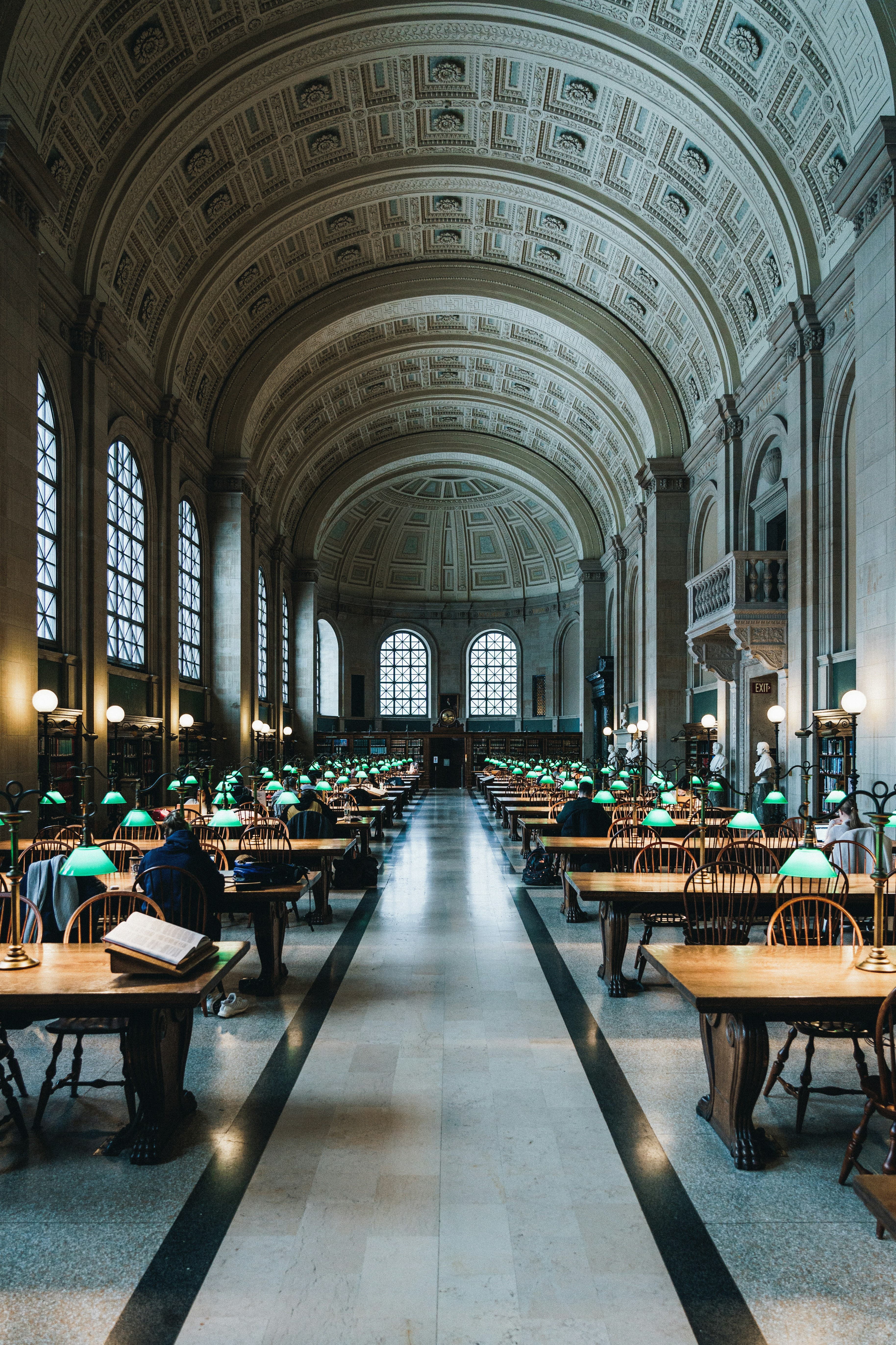 Simetrična čitaonica s lučnim stropovima i nizovima stolova sa zelenim lampama s obje strane središnjeg prolaza